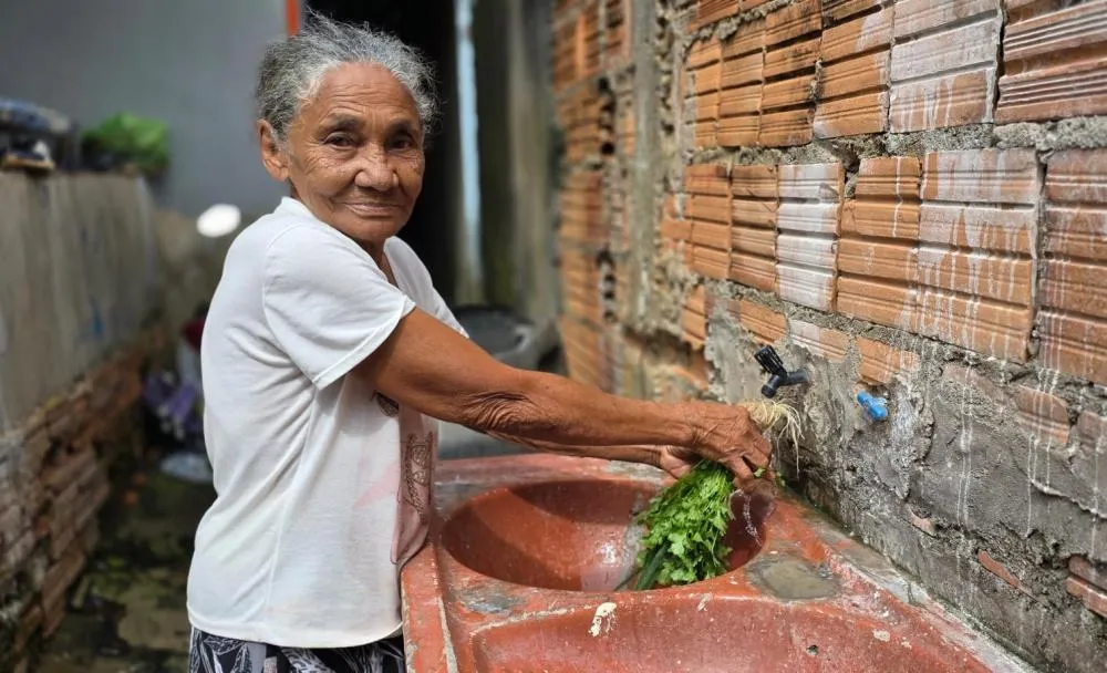 A aposentada Maria dos Reis celebra abastecimento regular após 24 anos
